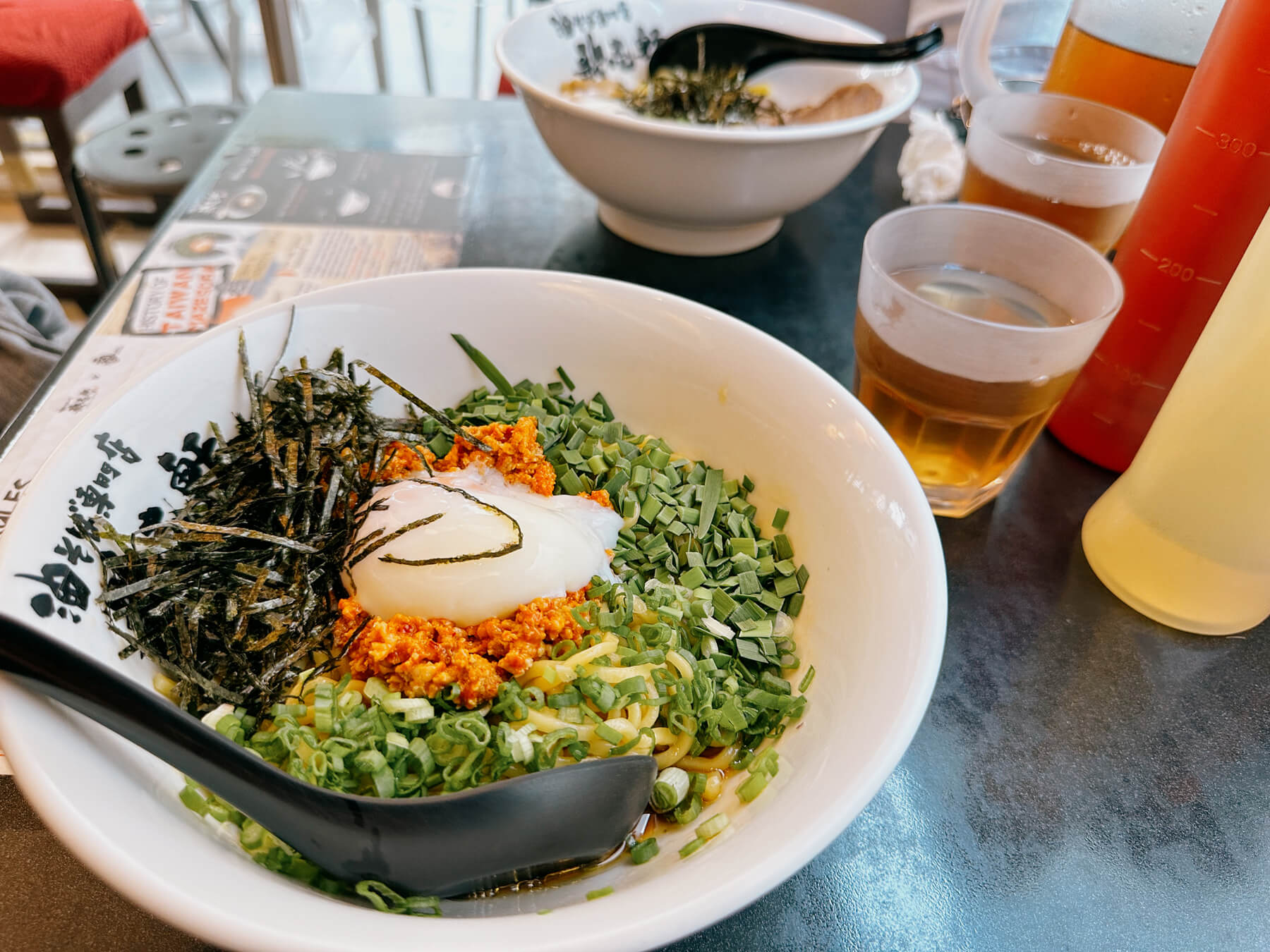 a photo of dry ramen-like noodles with many toppings, including a soft boiled egg