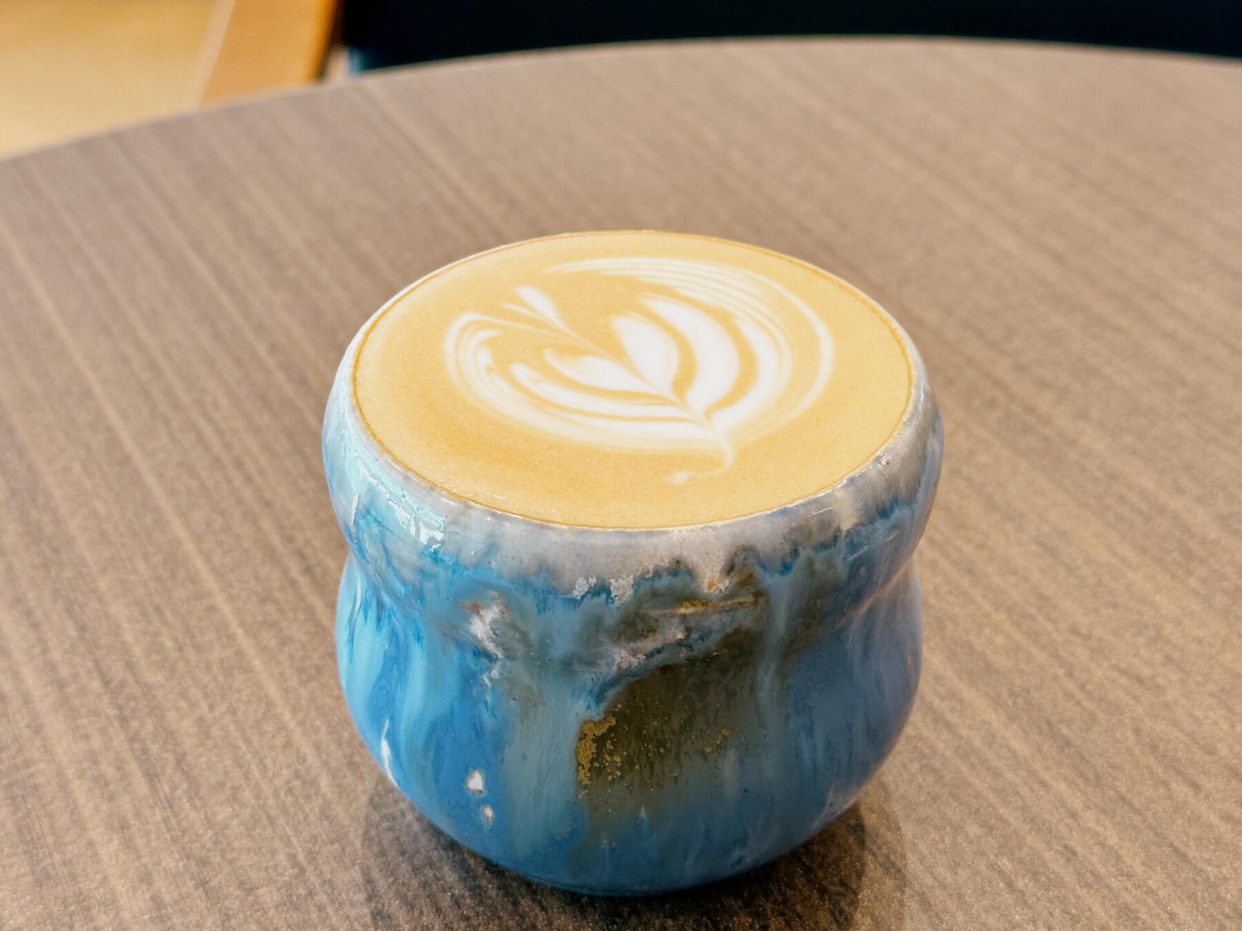 a photo of coffee in a beautiful ceramic cup on a wood table