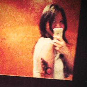 Close-up photo of a Battlestar Galactica-inspired tattoo with wing and constellation motif.