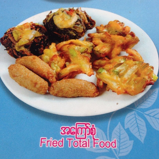 a photo of a menu item in Myanmar with fried food, and Burmese and English word that say TOTAL FRIED FOOD