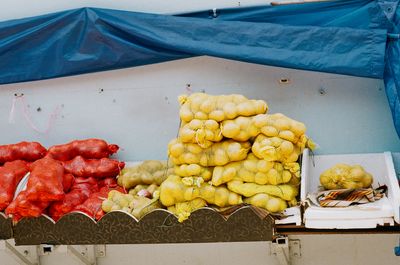 3. A scan of onions and potatoes being displayed at a little India grocer with a blue tarp over it