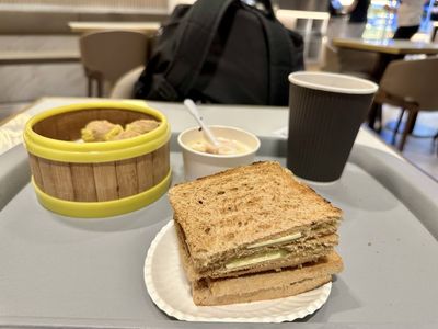 A photo of a Singaporean breakfast of kaya butter toast, siew mai, eggs and coffee for breakfast