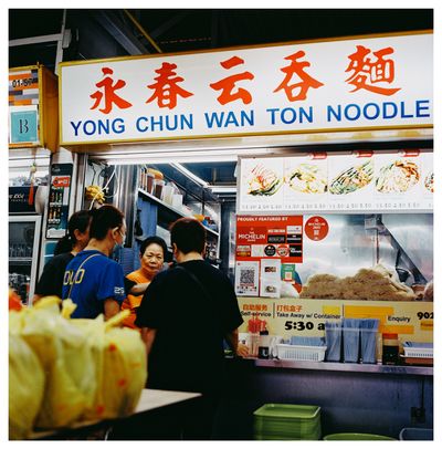 4. A scan of a medium format square color photo of a wanton noodle stall in Singapore that says Yong Chun wanton noodles