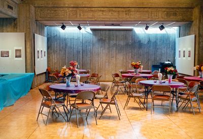 a scan of a color photograph showing some tables and chairs in an indoor church setting