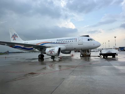 A Nepal Airlines plane parked on a wet airport apron beneath a cloudy sky