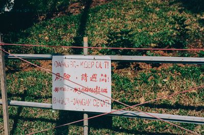 a scan of a color photo of danger, keep out sign in 4 languages