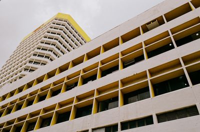 a scan of a color photo showing a geometric office building juxtaposed against another one