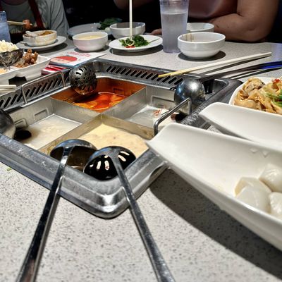 a photo of hotpot with four soups
