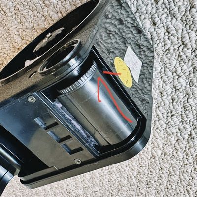 a photo of a film loader with a cassette in it and a red arrow pointing at where the spool should be pointed