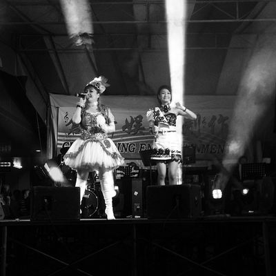 Black and white photo of two women singing on stage