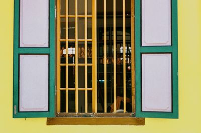 4. A scan of a color photo of colourful windows (painted green on wood and brown) with purple and green and bright green or yellow colors around it