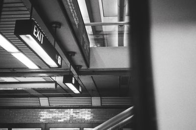 a scan of a black and white photograph of a train station signs and lights from inside a train