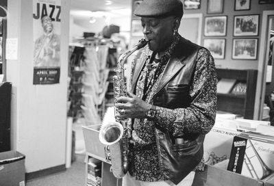 A musician playing saxophone in a record store