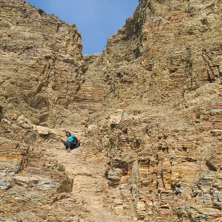 Person scrambling down a rock